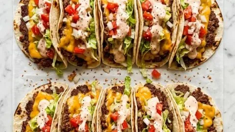 Delicious smash burger tacos topped with fresh ingredients and served on a plate.