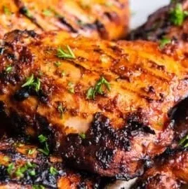 Smoky grilled paprika chicken served on a plate with fresh herbs
